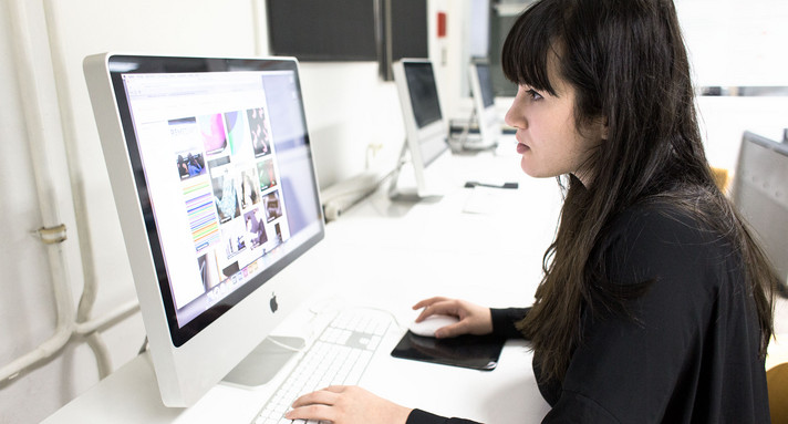 Eine Frau sitzt an einem Computer.